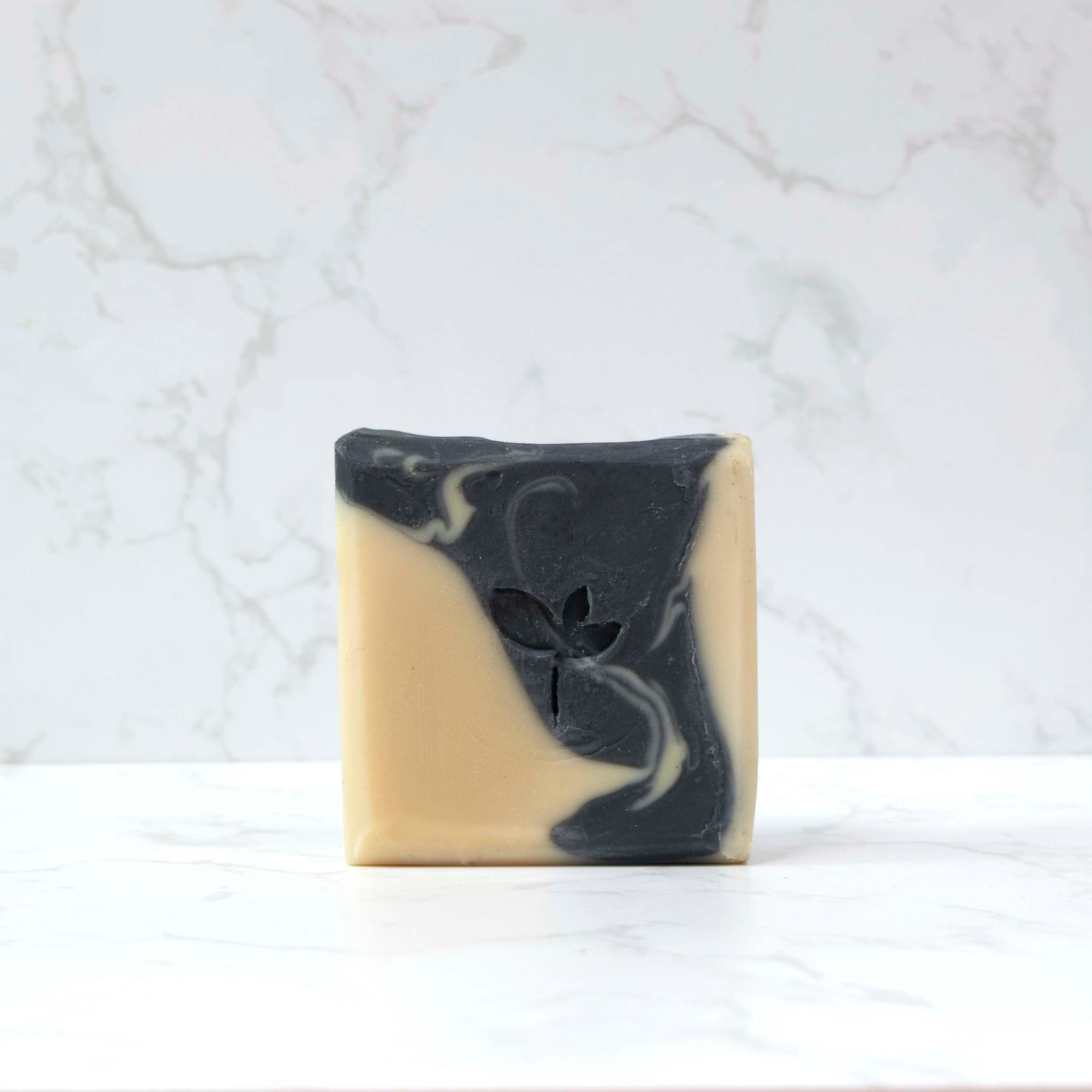 Cedarwood and stout natural soap bar with a marble background