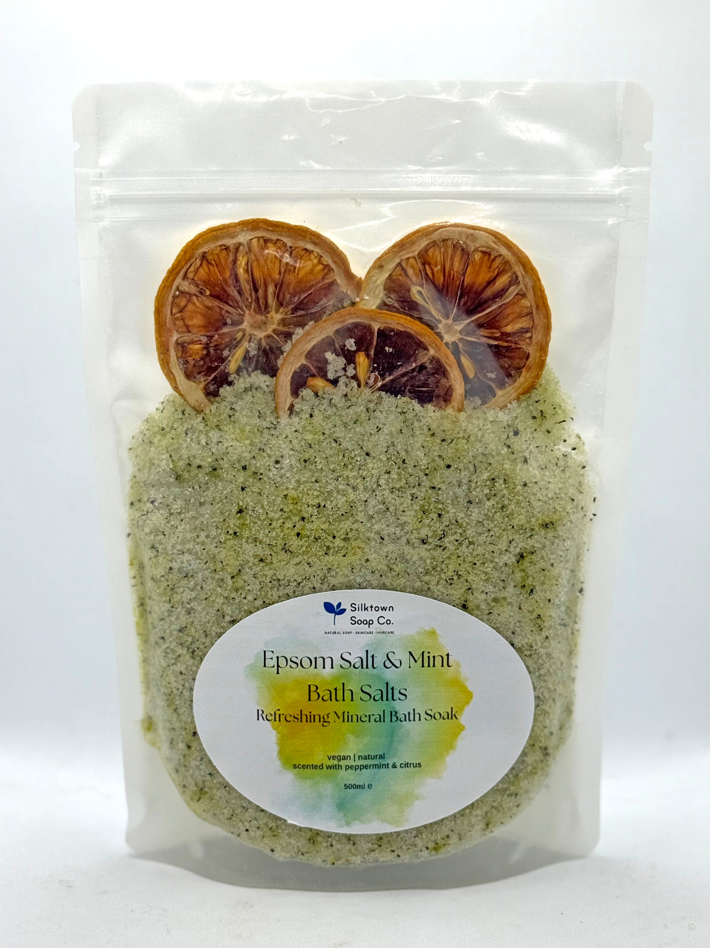 Packaged Epsom Salt & Mint Bath Salts with dried lemon slices on a white background