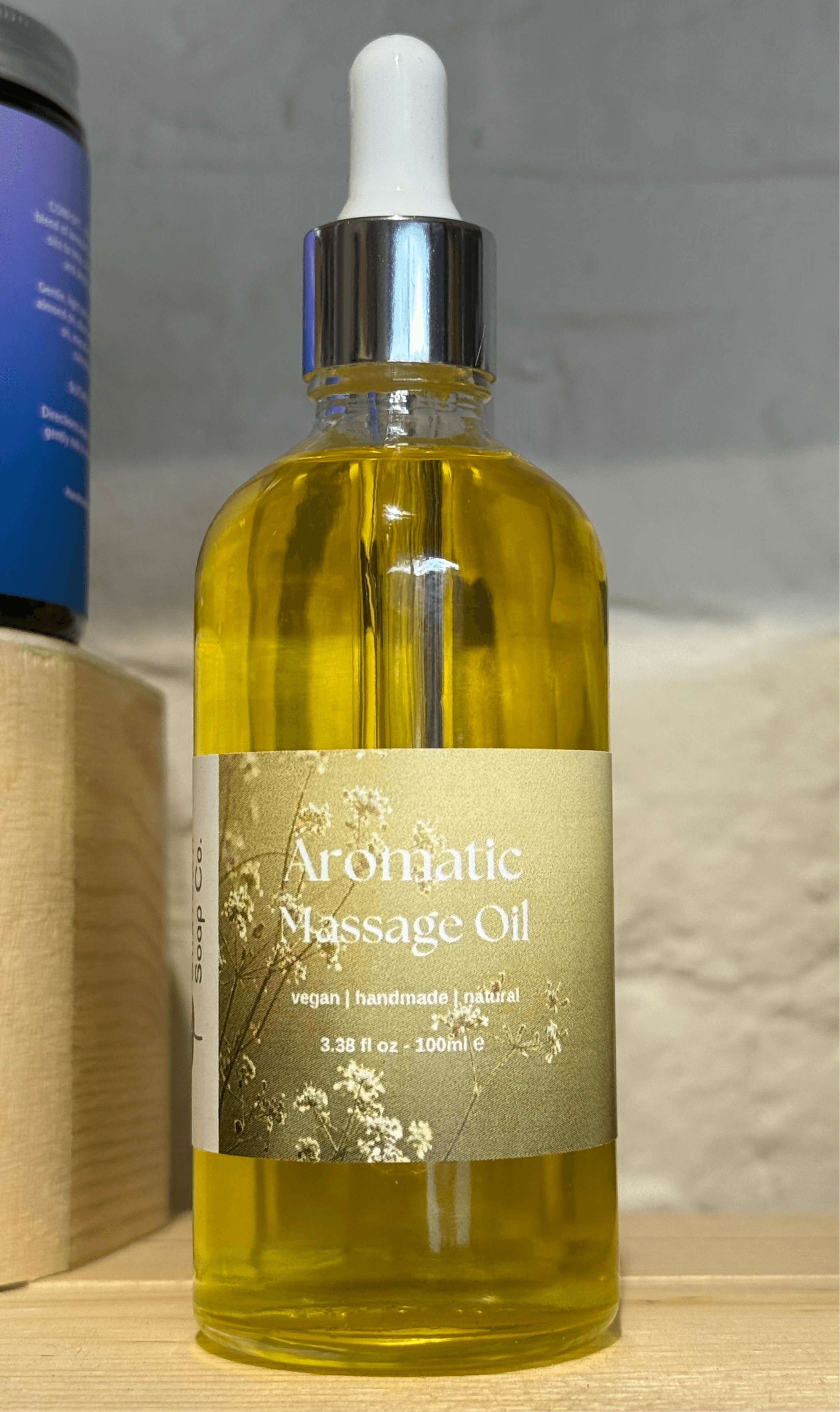 Aromatic nourishing natural body oil in a glass bottle with a dropper, featuring a label that reads &