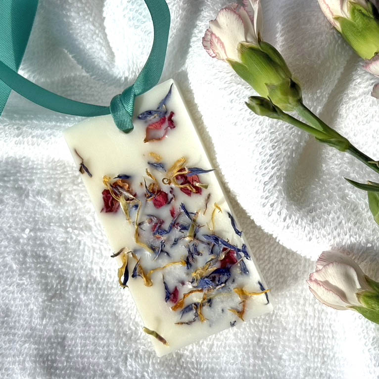 Natural Wax Freshener - Floral with a green ribbon on a towel with flowers