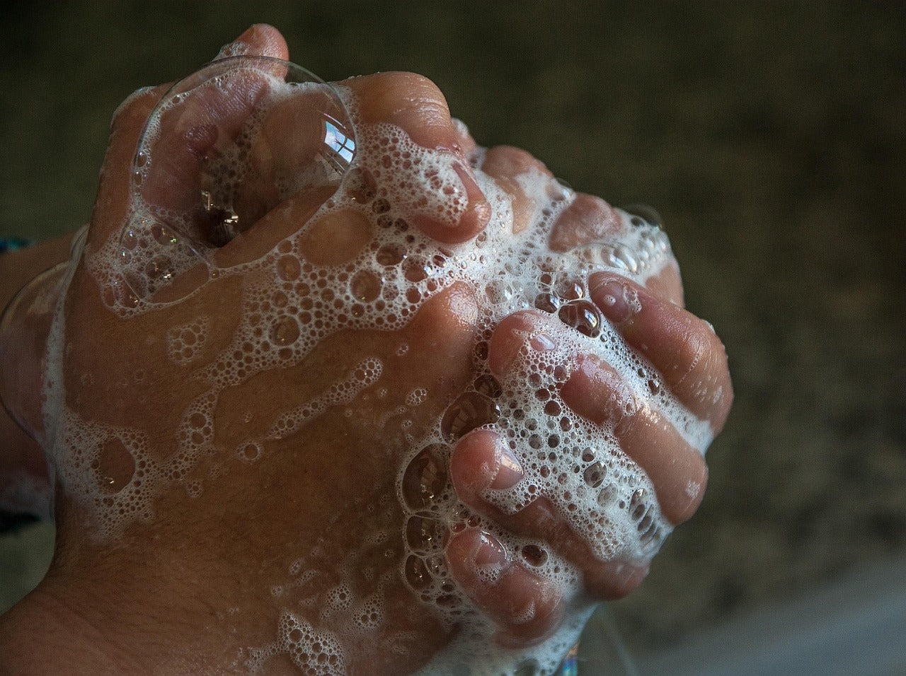 Hand with soap suds on a blurred background