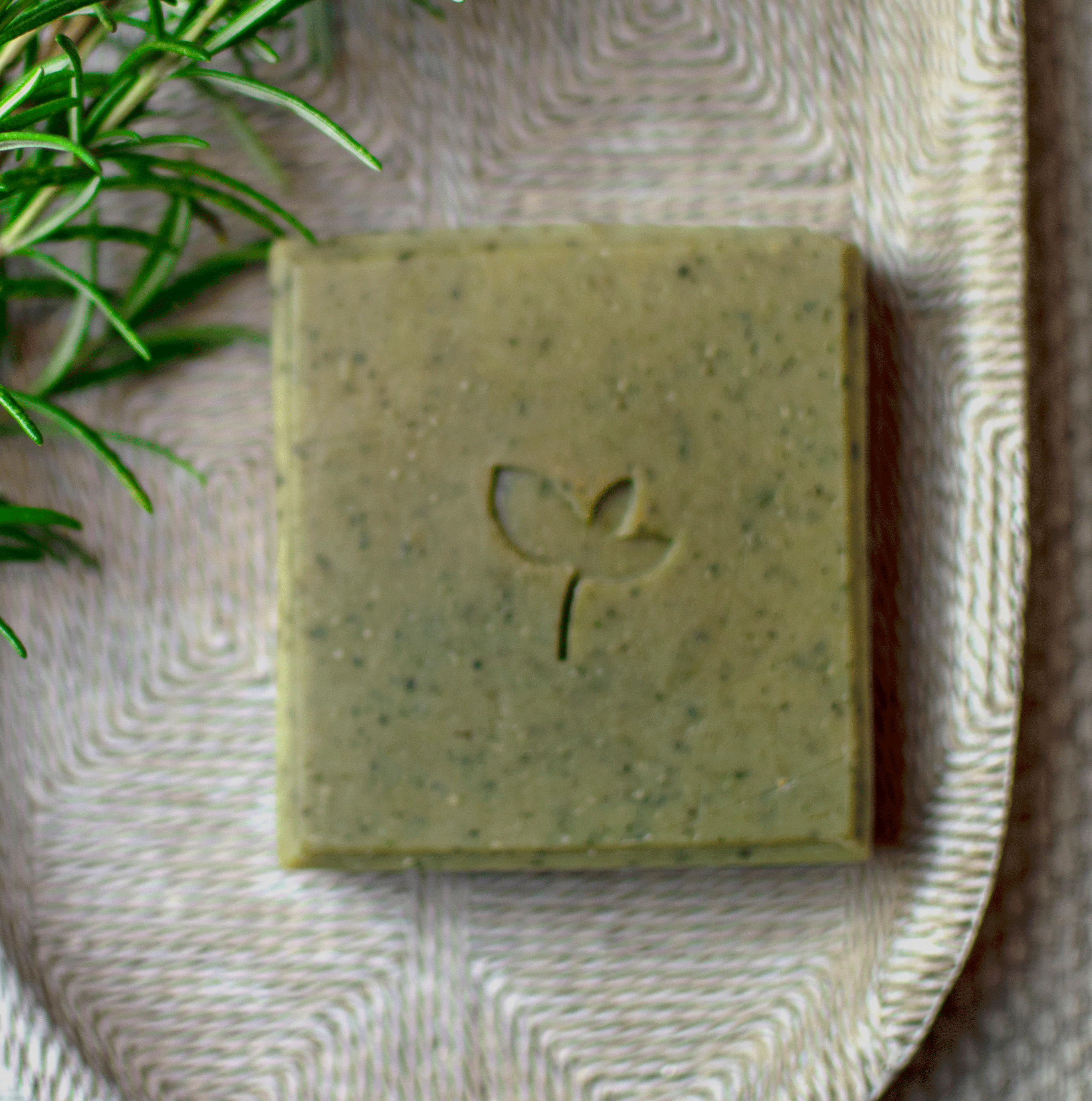 Persephone natural soap bar on a tray with a rosemary sprig
