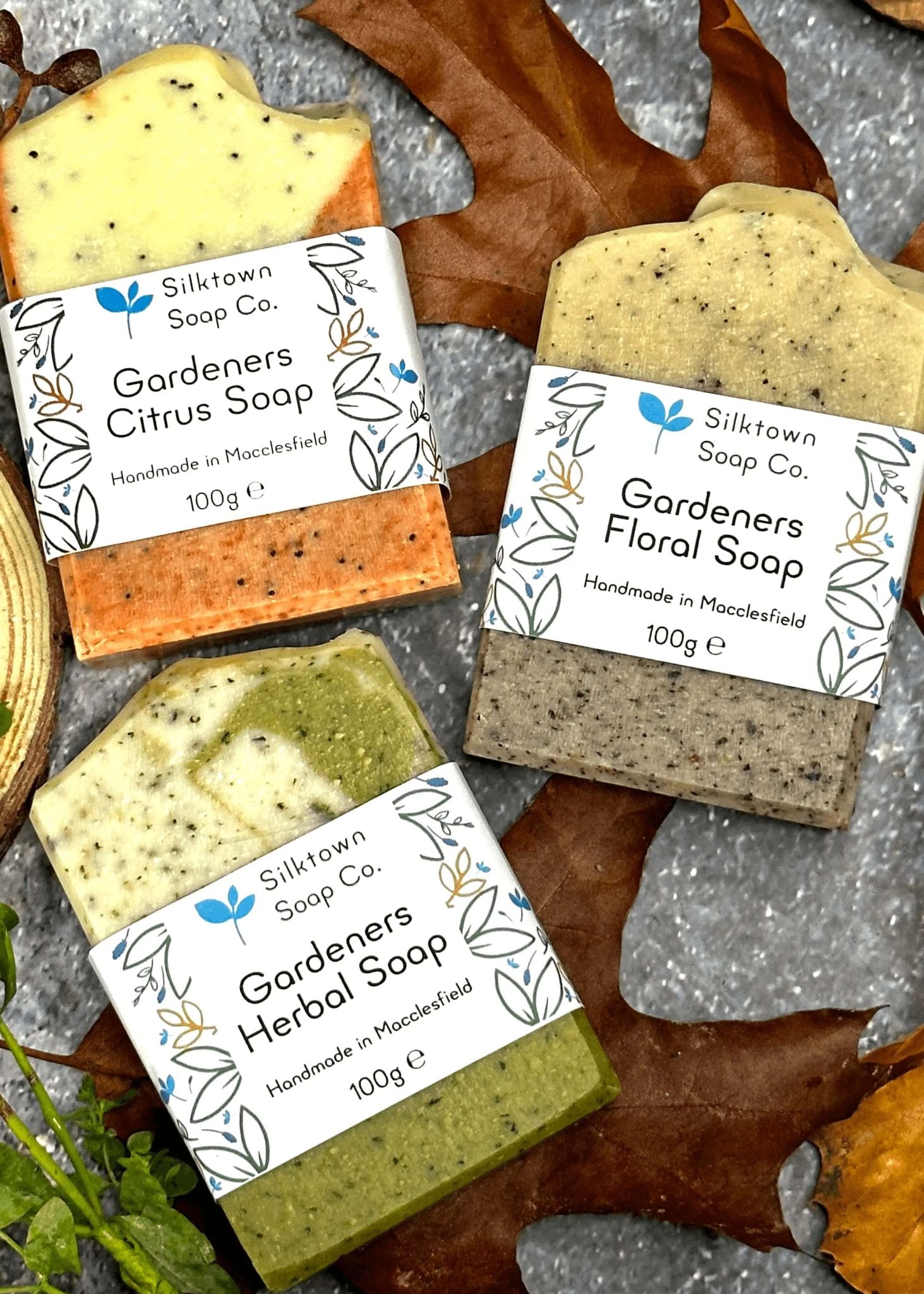 Trio of Gardeners natural soap bar on stone with leaves and wood