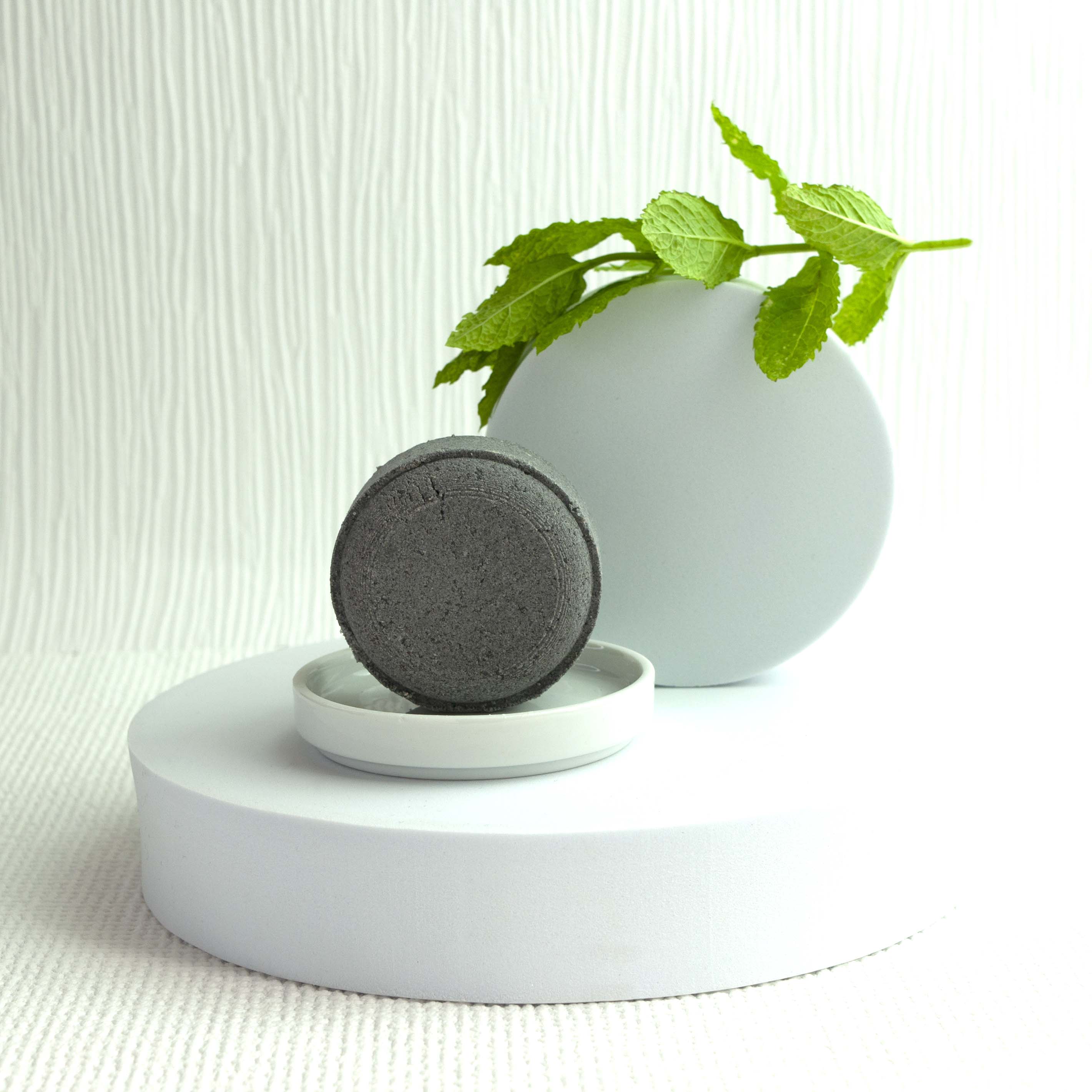 A Walk in the Clouds - Natural Skincare Bath Bomb displayed in a dish with mint and white display plinthes