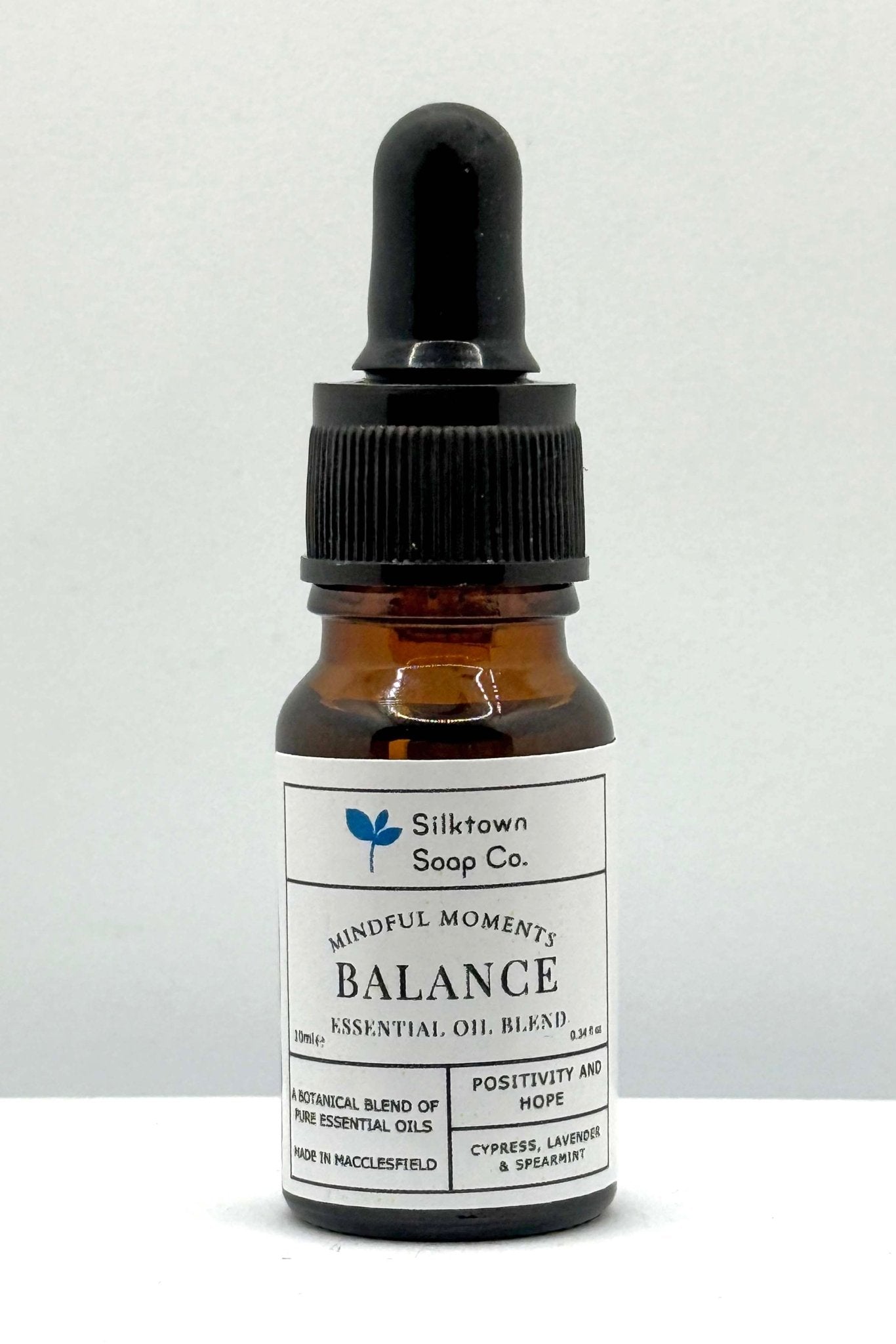 A small amber glass bottle with a dropper, labeled &