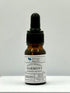 A small dropper bottle of Natural Essential Oil Harmony Blend with labels indicating the key ingredients such as Geranium, Pine, and Ylang-Ylang, and the brand Silly Billy.