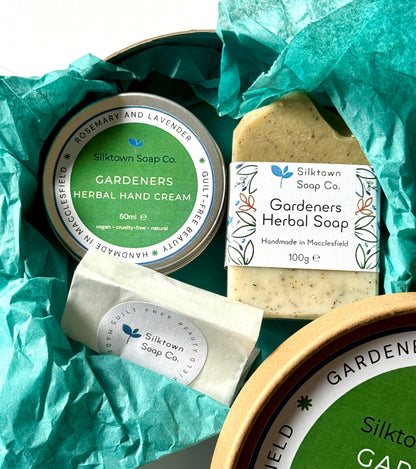 Silktown Soap Co. Natural Skincare products including a hand cream, soap bar, and tea bag on green tissue paper.