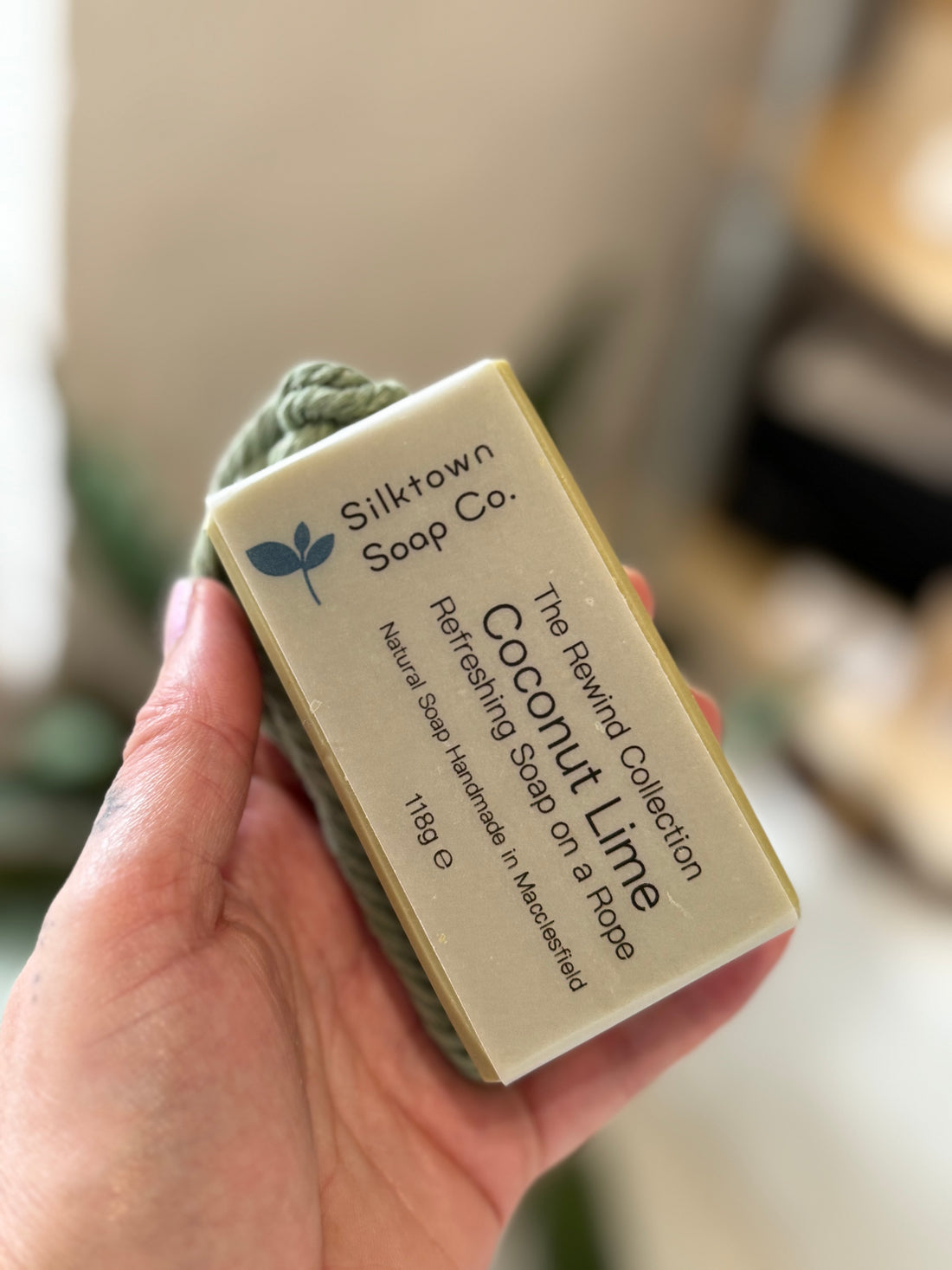 Coconut Lime soap bar on a rope held in a hand 