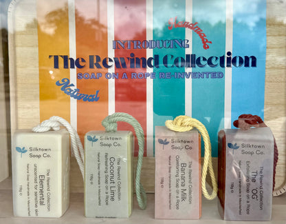 Bars of natural soap on a rope held in a box with coloured background  