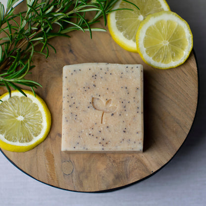 Citrus Crush natural soap bar with citrus slices and rosemary on a wooden board