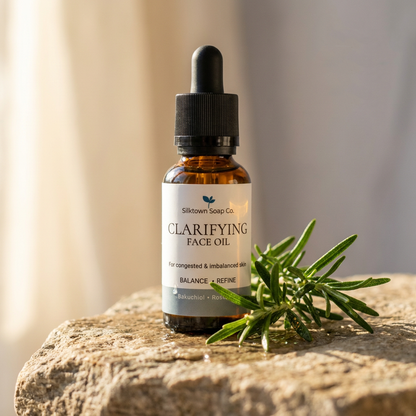 Clarifying face oil on lstone with sprig of rosemary