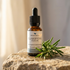 Clarifying face oil on lstone with sprig of rosemary