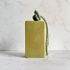A rectangular bar of green soap  featuring a knotted sage green rope loop at the top, set against a white marble background.