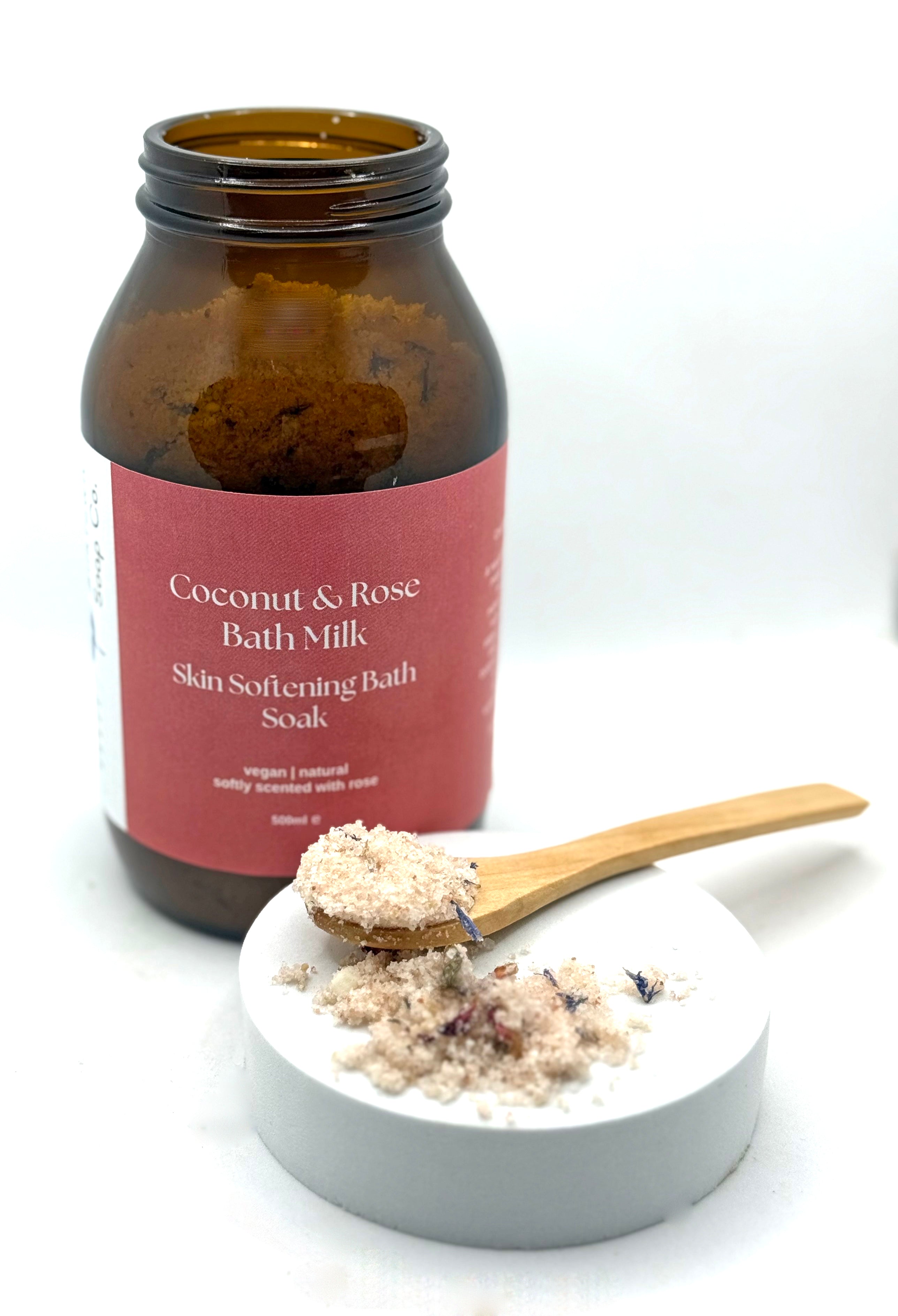 Coconut &amp; Rose Bath Milk with a wooden spoonful of product on a white background