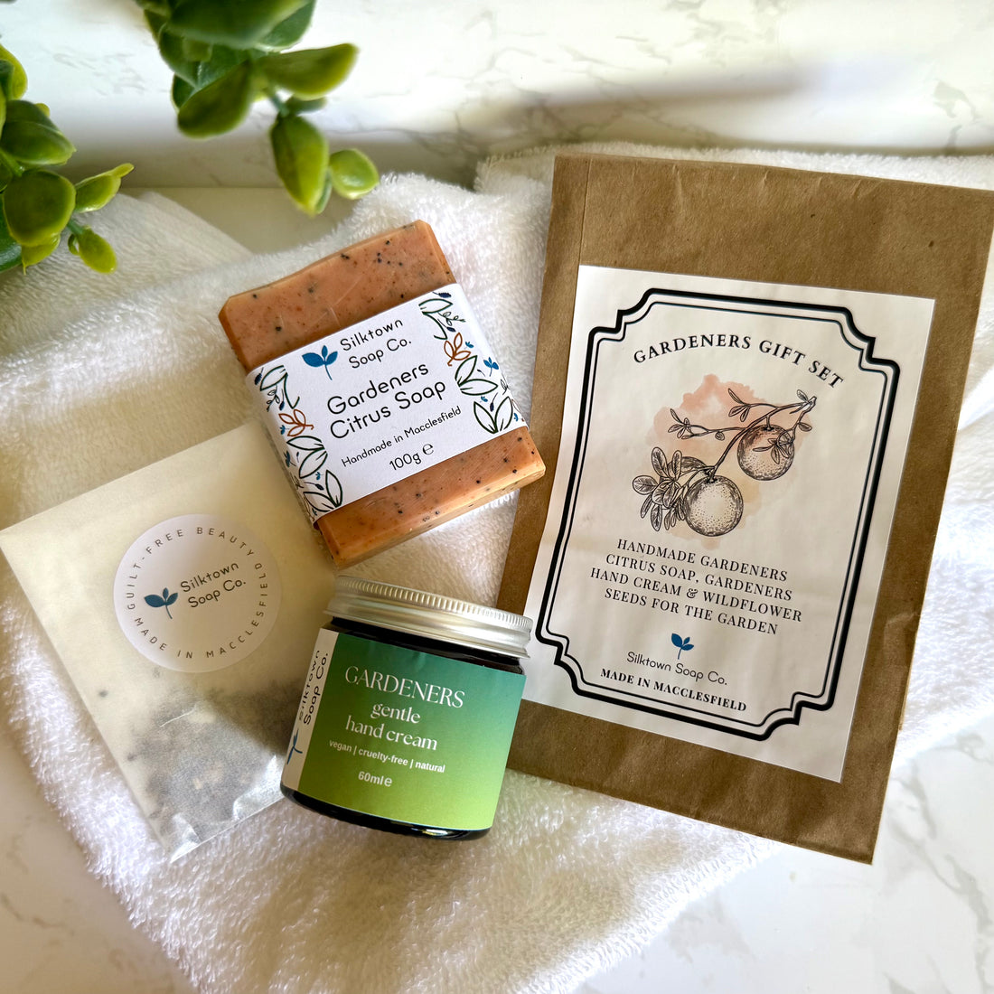 Gardeners gift set with soap, hand cream, and packaging on a white surface.