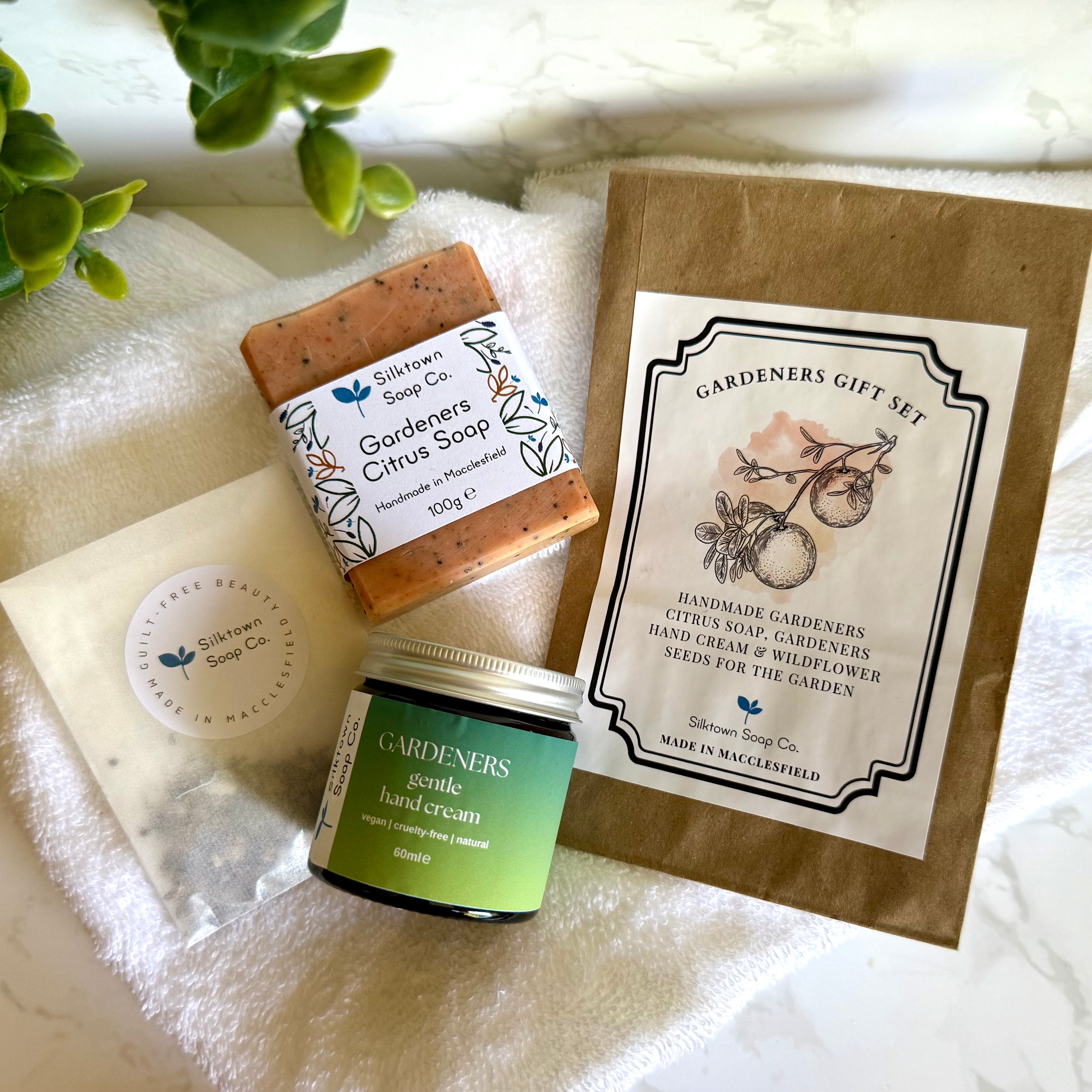 Gardeners gift set with soap, hand cream, and packaging on a white surface.
