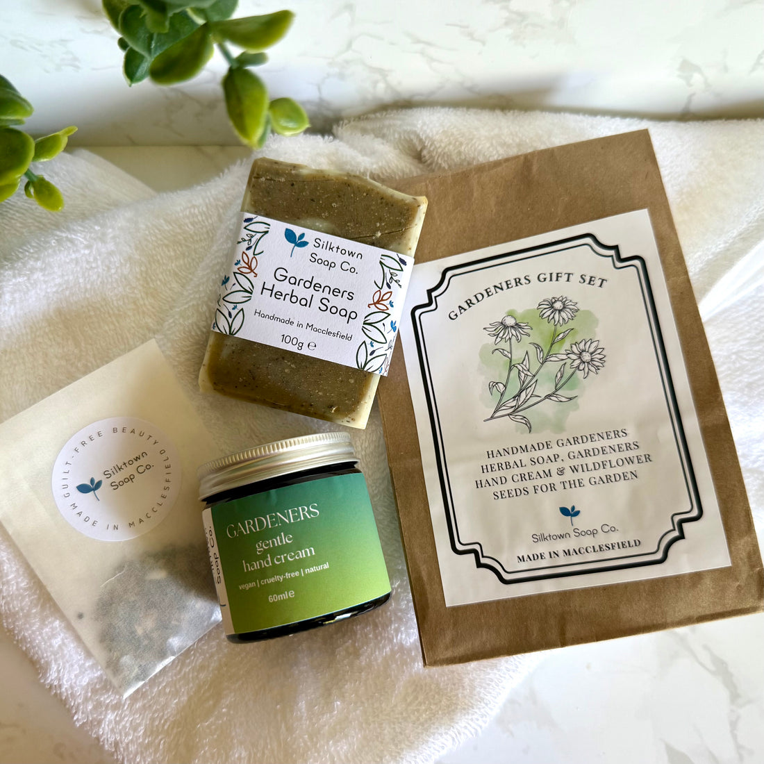 Gardeners gift set with soap, hand cream, and seeds on a white surface.