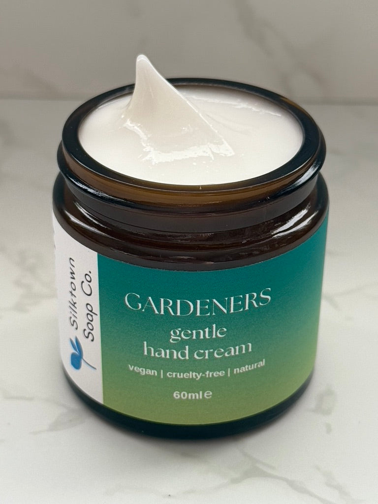 Open Jar of Silktown Soap Co. Natural Hand Cream - Gardeners Herbal on a neutral backgroundon a marble surface