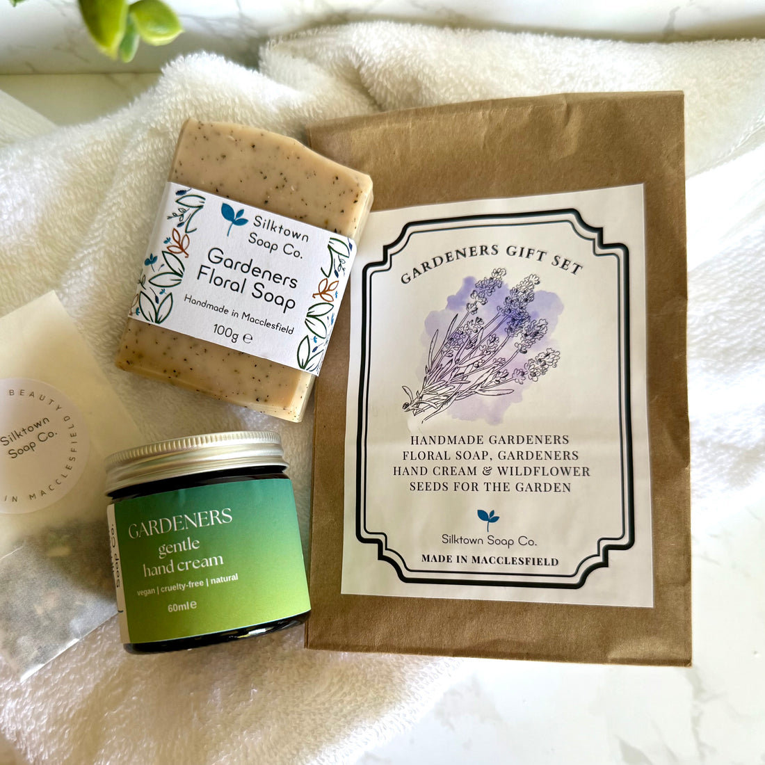 Silktown Soap Co. gardeners gift set with soap, hand cream, and seeds on a white towel.