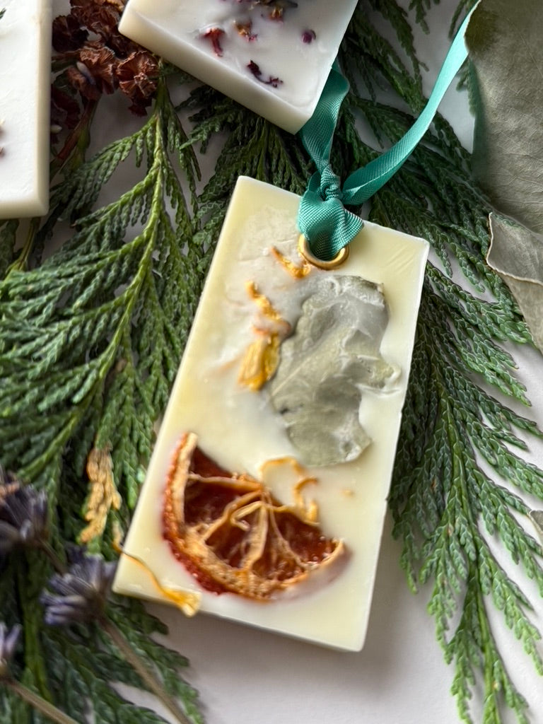 Citrus infused natural hanging wax fresheners with ribbon on top of cedar 