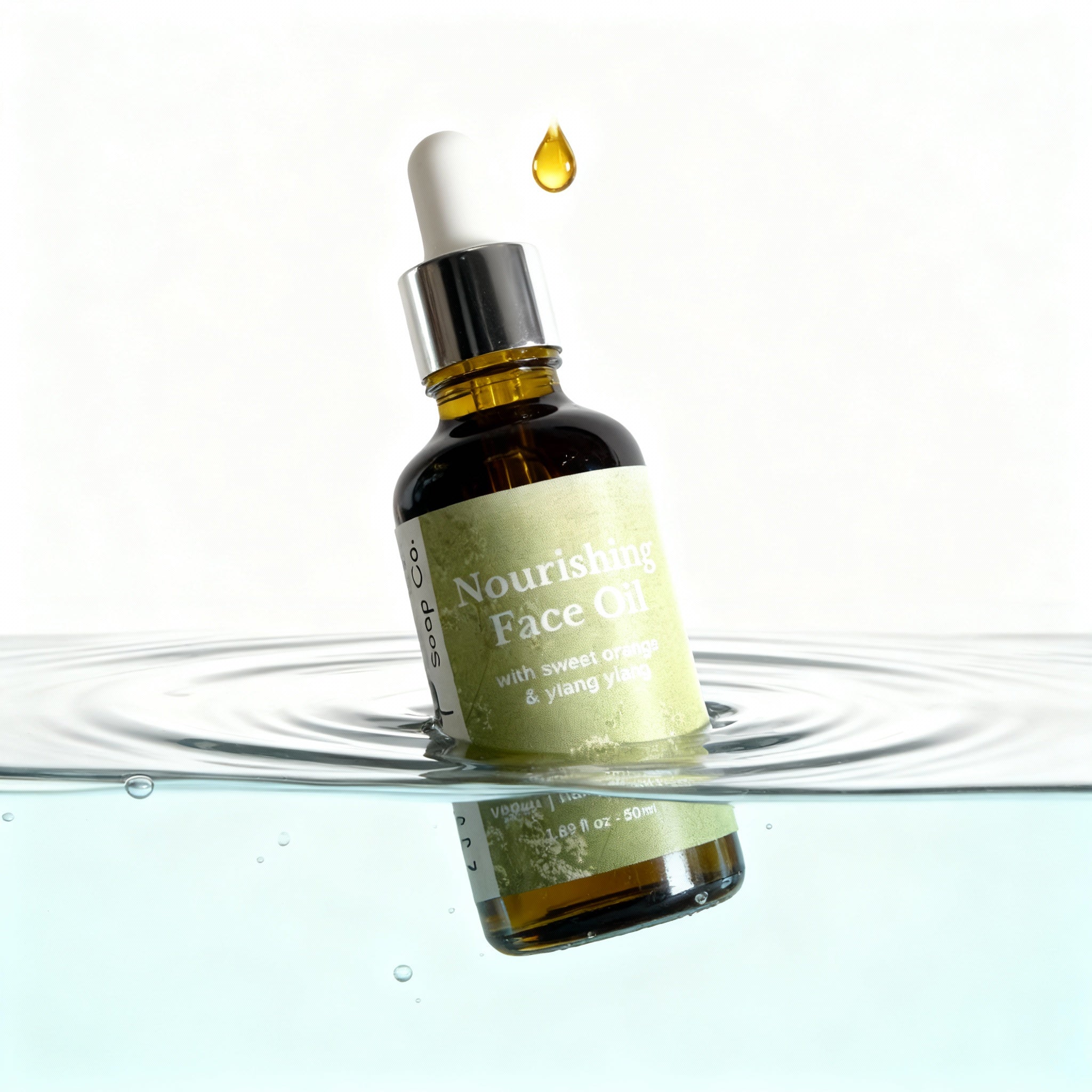Bottle of Nourishing Face Oil with a droplet above it, placed on water.
