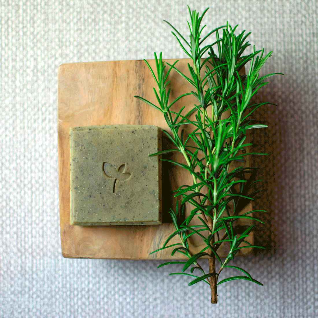 Persephone handmade soap bar with Rosemary on a board