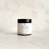 A small black cosmetic jar of Silktown Soap Co. Reviving Skin Cream with a white label, set on a light marble surface against a matching marble background.