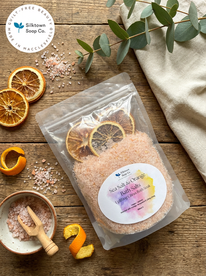Sea salt &amp; orange bath salt surrounded by slat and citrus slices and a towel