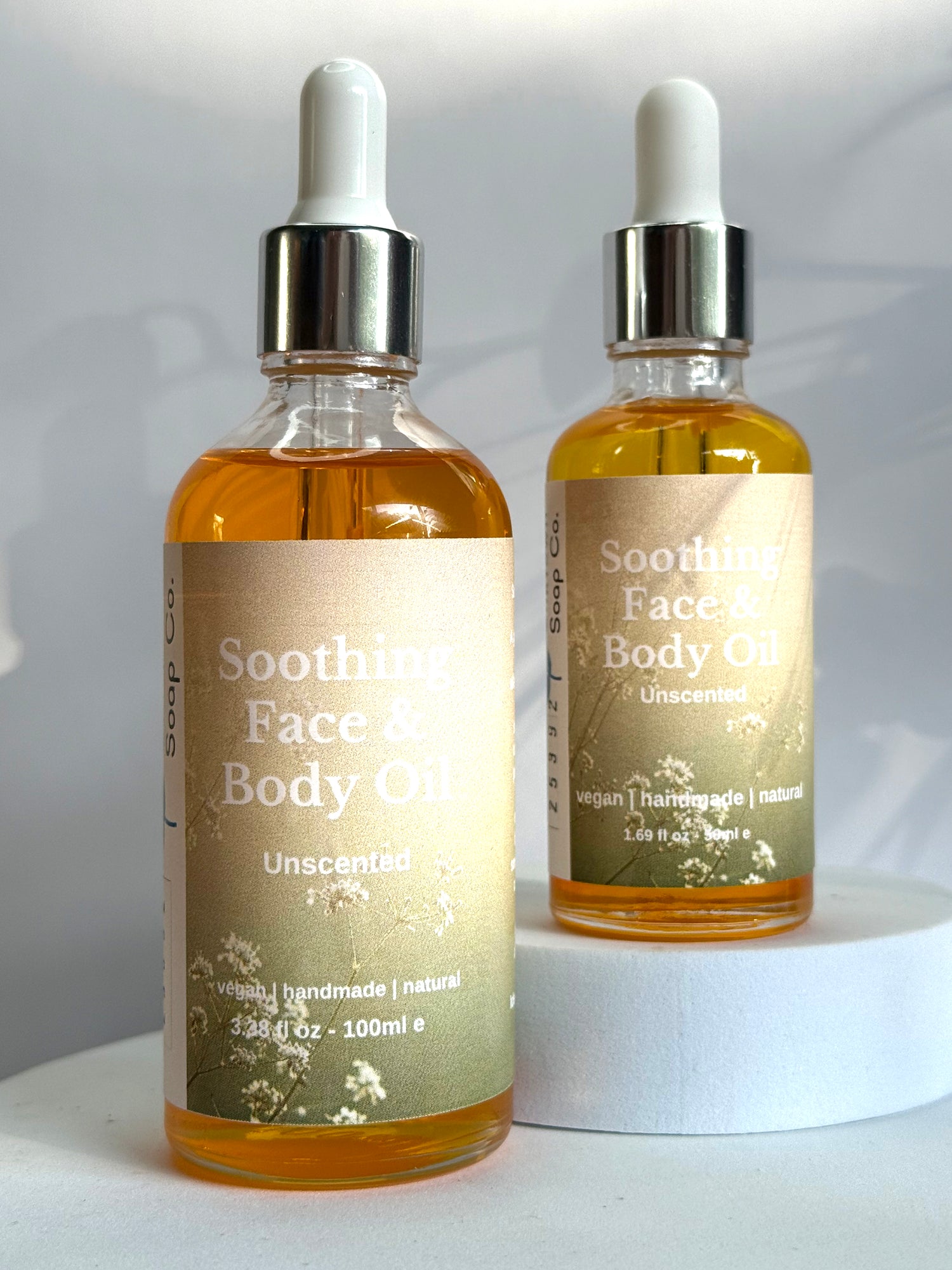 Two bottles of Soothing Face &amp; Body Oil on a white background
