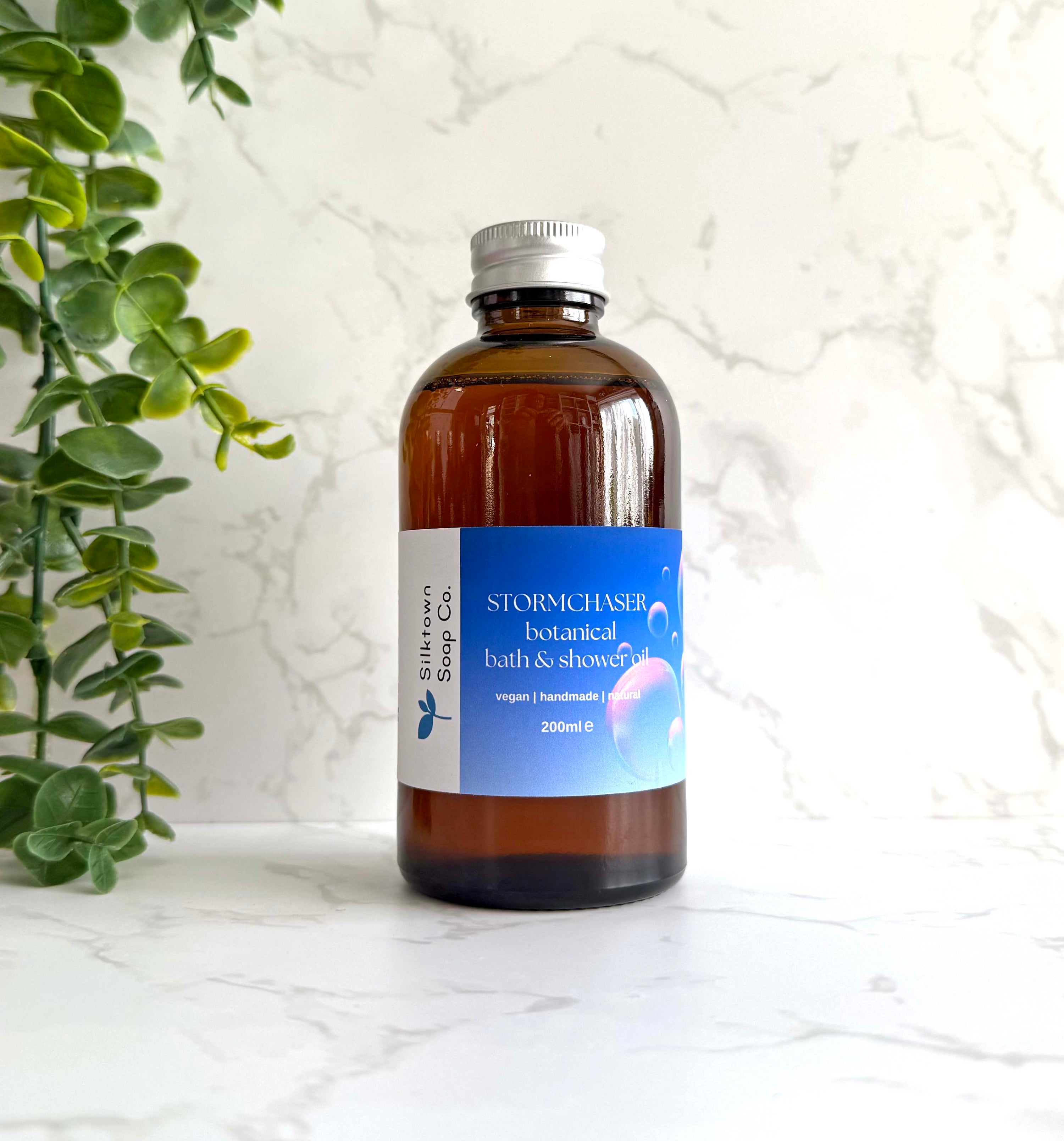 Stormchaser - Natural Skincare Foaming Bath &amp; Shower Oil with marble background and foliage