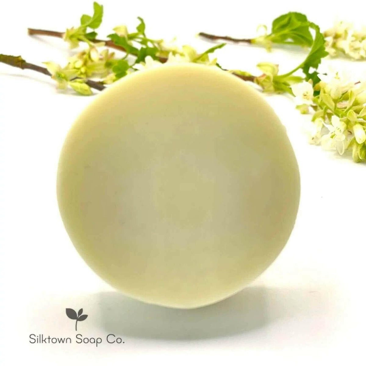 Neroli &amp; Lavender Natural Conditioner Bar with a sprig of foliage in the backgound and Silktown Soap Co. Logo