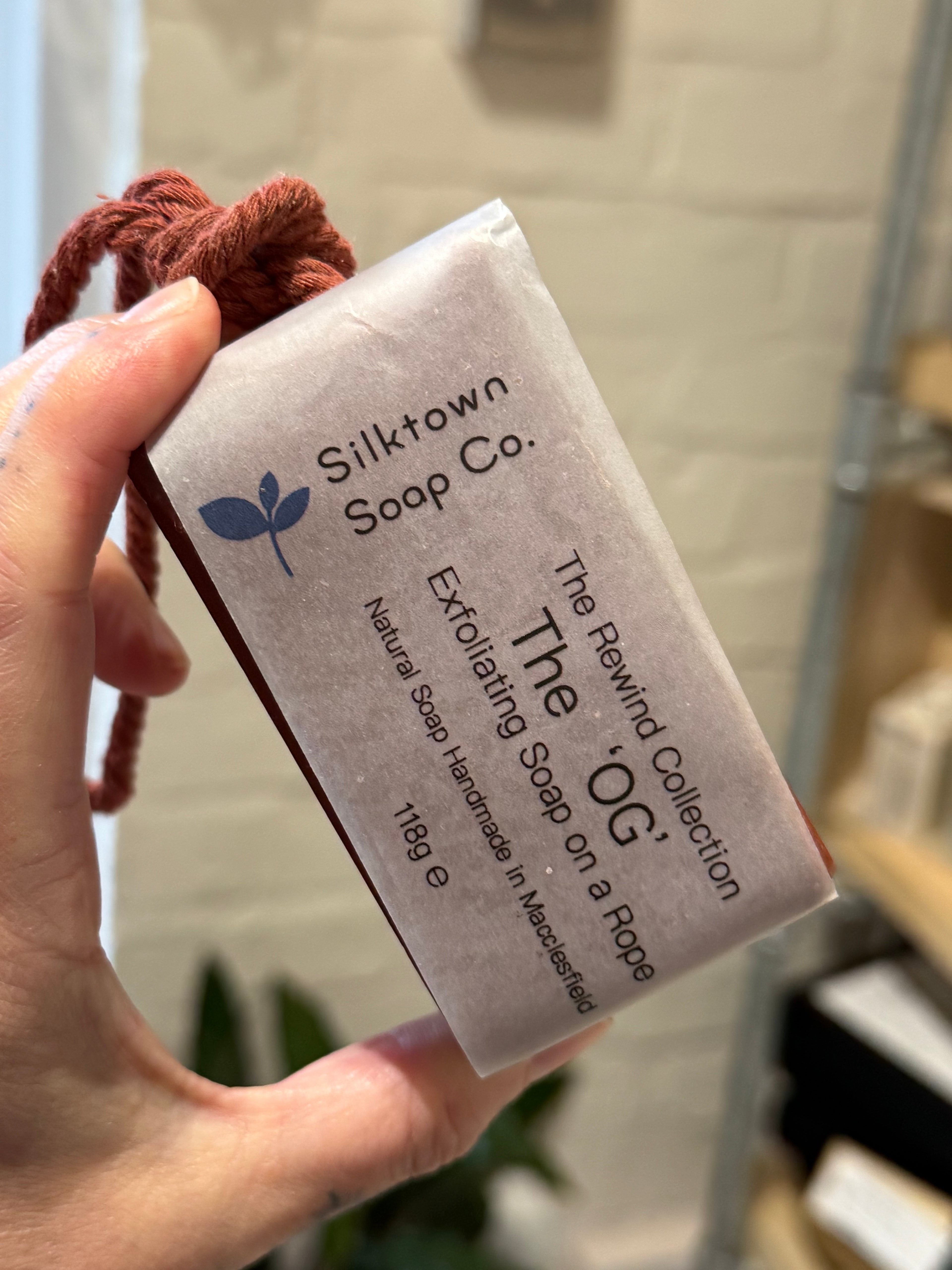 exfoliating natural soap on a rope held in the hand