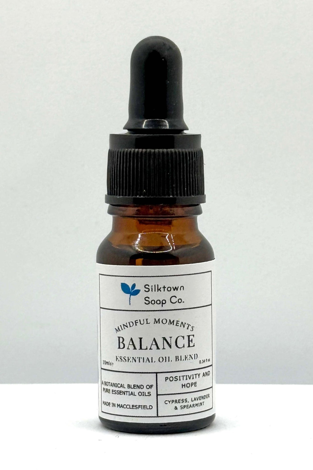 A small amber glass bottle with a dropper, labeled &