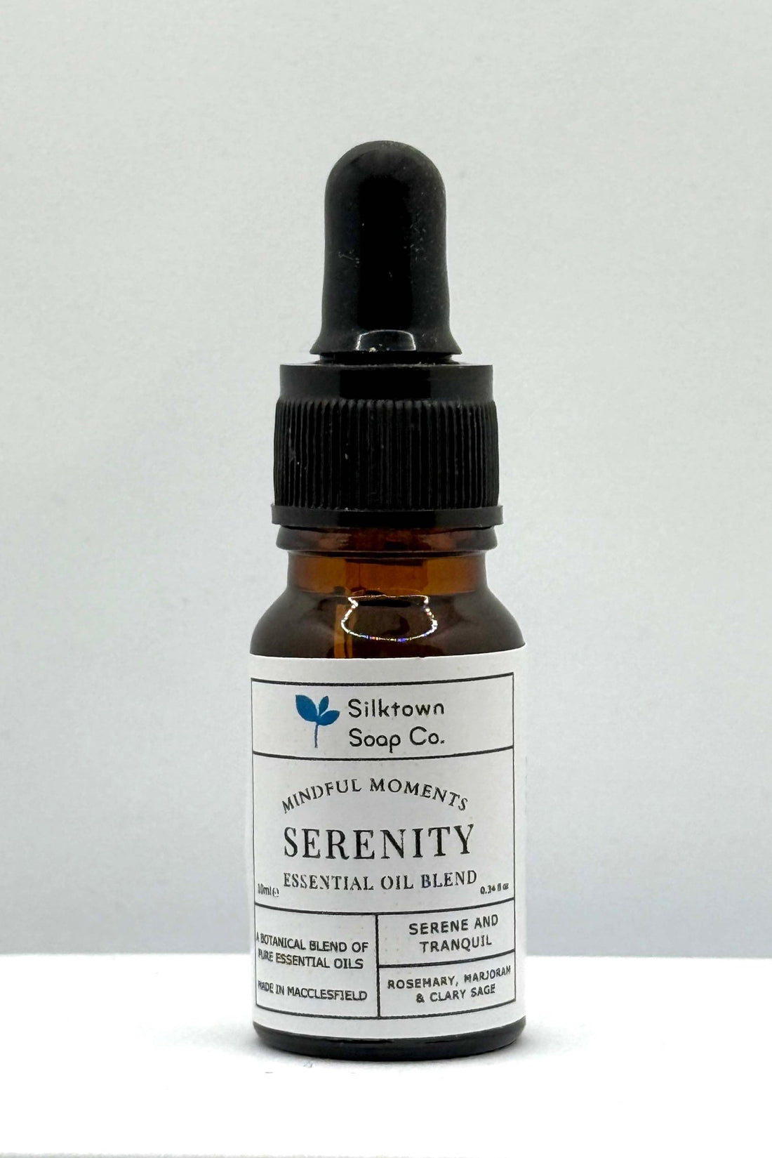 A small dropper bottle of natural essential oil labeled &