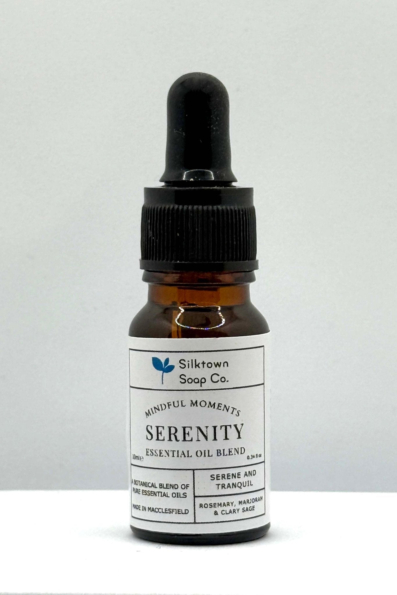 A small dropper bottle of natural essential oil labeled &