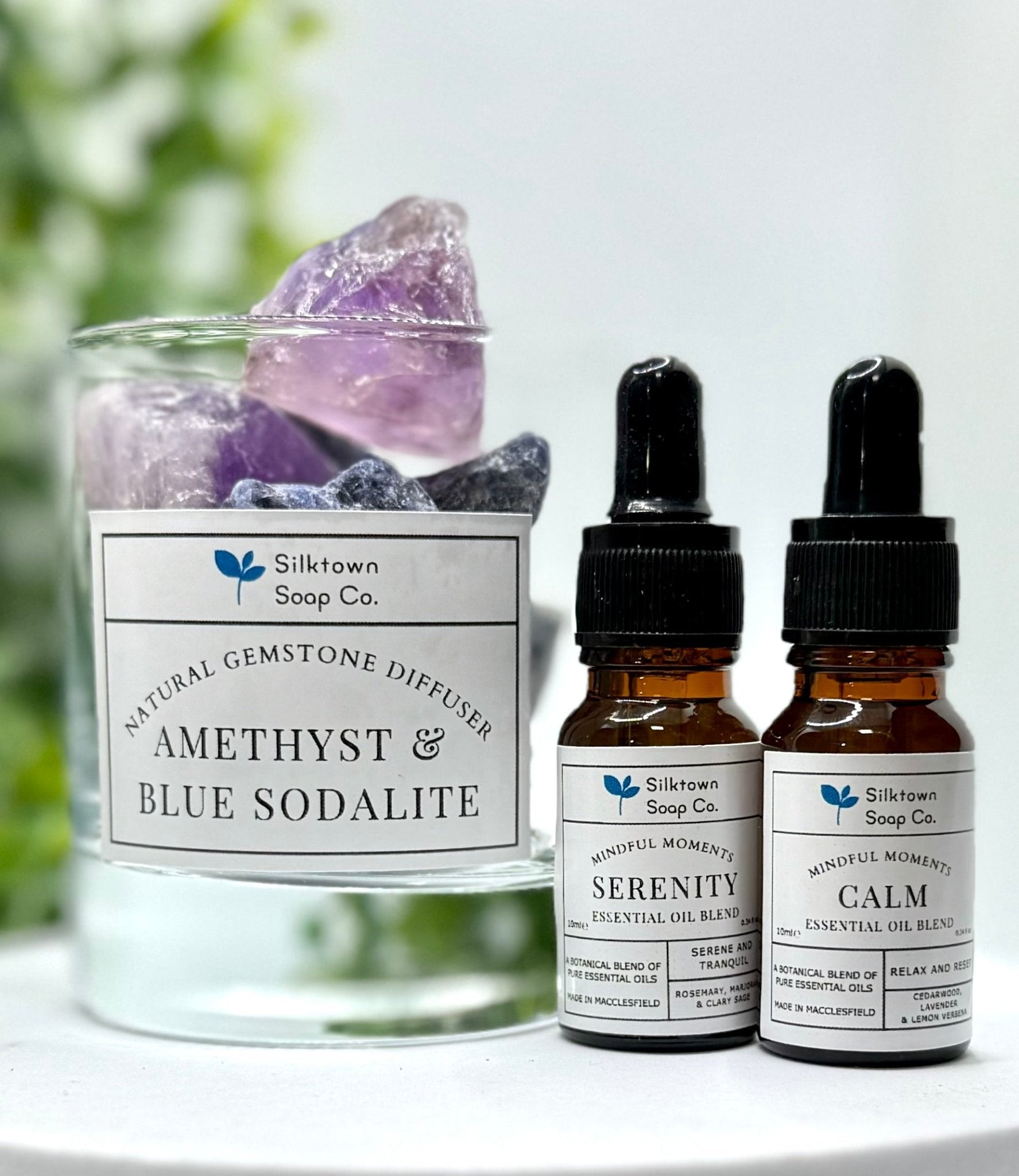 Natural essential oil blends with a gemstone diffuser and foliage in the background