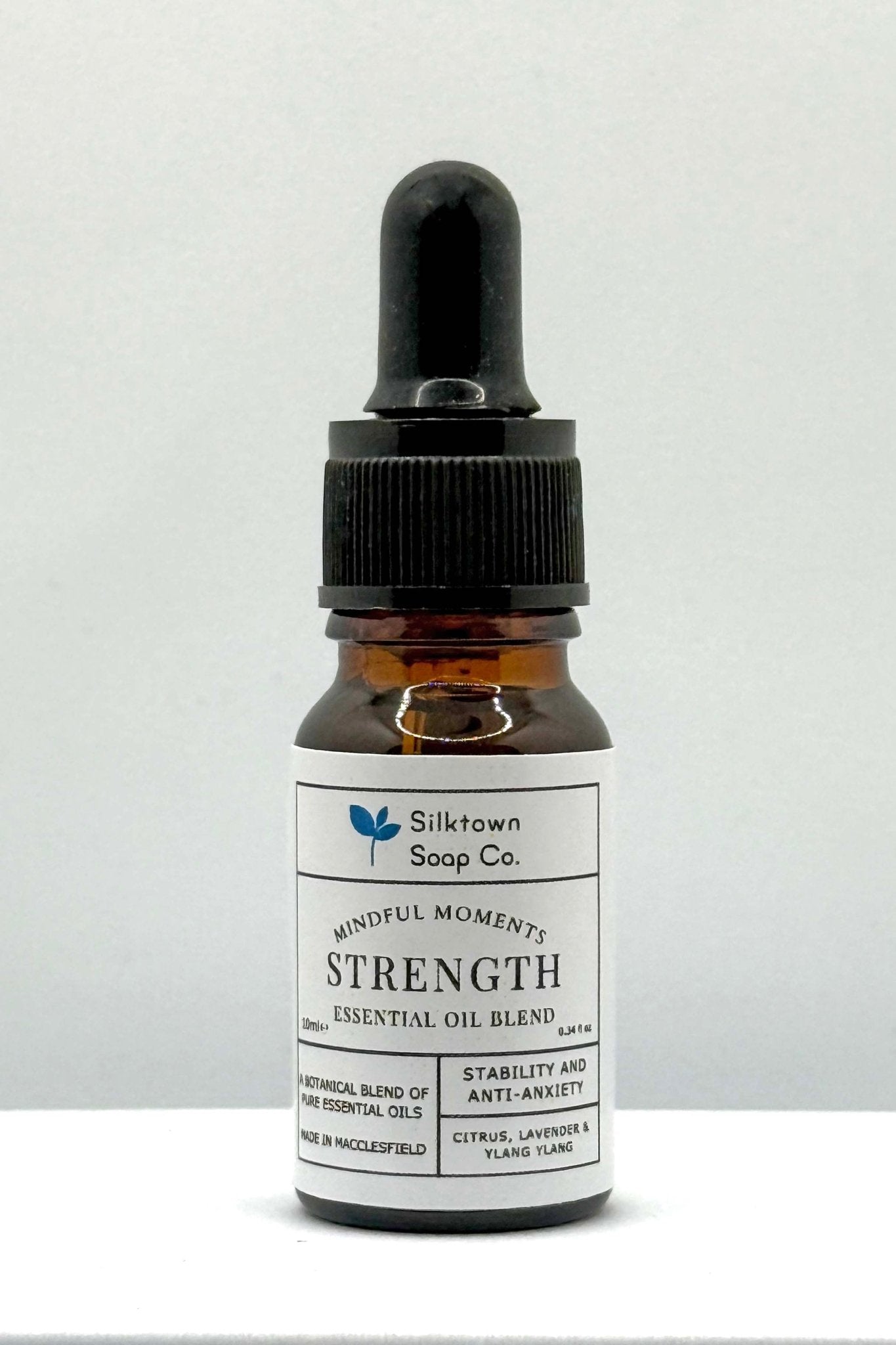 A small dark glass bottle with a dropper, labeled &
