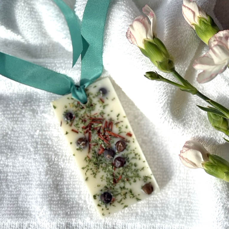 Natural Wax Freshener - Woodland with a green ribbin on a towel with flowers